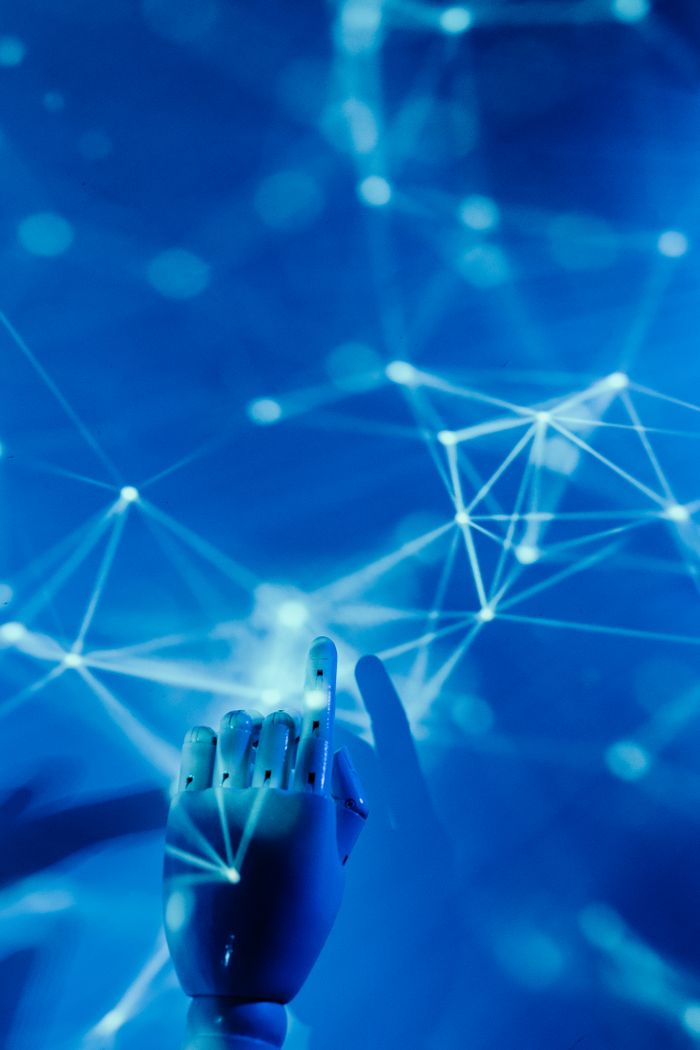 The Art of Drawing Readers In: Your attractive post title goes here Futuristic robotic hand touching a digital network on a blue background.